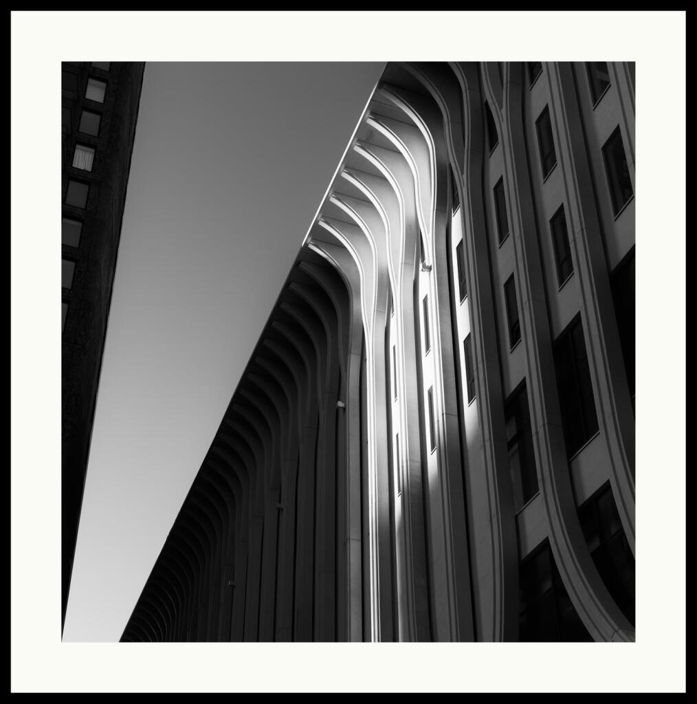 b&w - a strip of light hits and illuminates a section of verticals of the amare building in down town the hague.