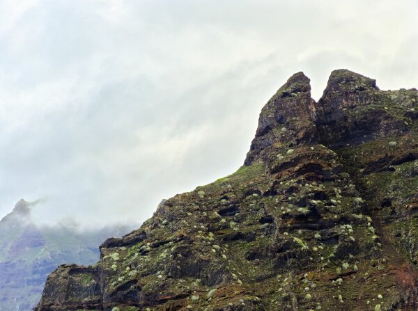 landscape fragment with rocky volcanic mountain and clouds on tenerife