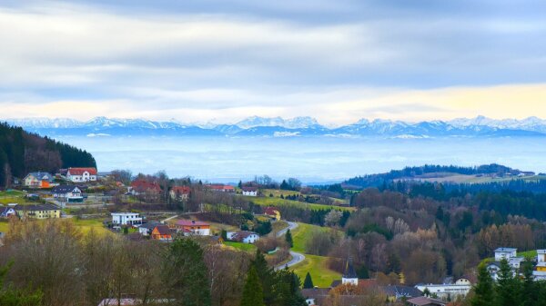 View of the village rechberg in the mühlviertel, upper austria, with the alps in the background in early spring