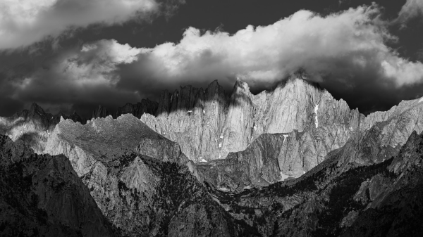 Clouds shade the mountaintop spires from the morning light. 